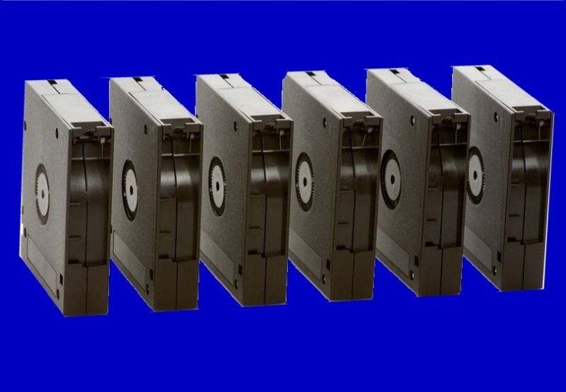 A series of DLT tapes shown lined up in a row. The tapes were used with Retrospect on an old Apple Mac under OS9 software. They had their data read and transferred to DVD and USB hard disk. 