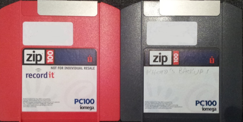 A pair of PC100 ZIP disks photographed side by side. The disk on the left is red, and the right hand one is blue. Both disks are manufactured by Iomega.