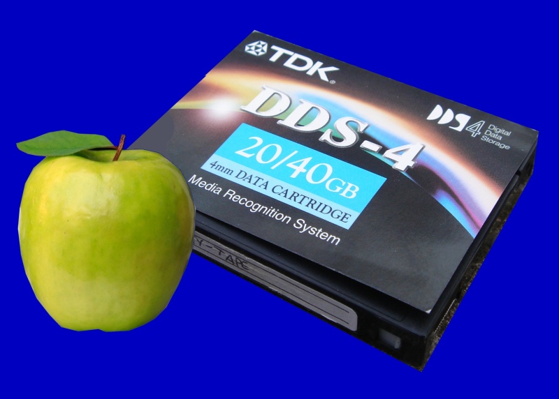 A Dat Tape that was used by Retrospect Backup software on an Apple Mac. Also in the picture is an Apple.