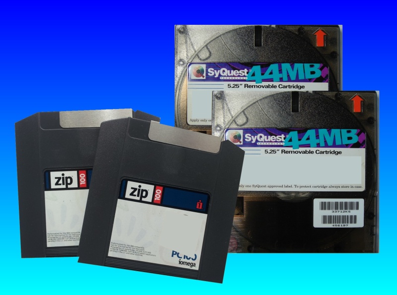 A pair of ZIP 100mb and a pair of Syquest 44mb disks are shown stacked together and awaiting data transfer to email and download files back to the customer. The disks were formatted in an Apple Mac and contained artwork project.