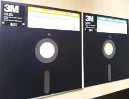 There are 2 off 8 inch floppy disks made by 3M shown side by side awaiting us to recover the files inside the diskettes to a cd or USB. The disks are dark grey in colour and with white hand written labels. Their printed labels indicated 3M SS SD single side single density 740-0 26 soft sectors / 128 bytes. 