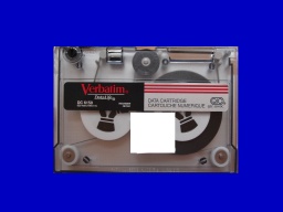 An old 5.25 inch tape cartridge by Verbatim shown against a blue background. This tape was used in Sun Sparc stations and AIX computers. We can dump and restore tar archives from the tpaes to USB, hard drive, CD, or DVD.