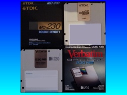 A TDK 230MB MO disk and a Verbatim 230mb disk are shown with the case inlay cards. These Magneto Optical disks measure 3.5inches and are commonly used on consumer products from the late 1990s to 2000s. 